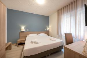 a bedroom with a large white bed and a desk at Hotel Capinera in Caorle +44 photos