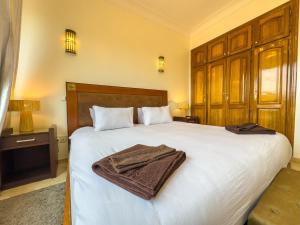 马拉喀什Elegant 2-BR, Pool And Parking Hivernage Centre的卧室里有一张大床，床上铺着毛巾。