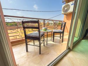 马拉喀什Elegant 2-BR, Pool And Parking Hivernage Centre的阳台上有两把椅子和一张桌子