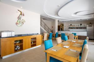 a dining room with a table and blue chairs at Luna Boutique Hotel in Mindelo