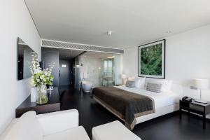 a bedroom with a large bed and a bathroom at Troia Design Hotel in Troia