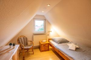 a attic bedroom with a bed and a window at Bauernhof Diestel in Oldau
