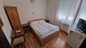 a small bedroom with a bed and a television at Pensiunea Olimp in Arad