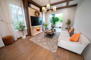 a living room with a white couch and a tv at Chang Luxury Villa Beach View in Bình Tú