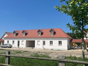 a large white house with a red roof at gites des polders in Saint-Quentin-en-Tourmont