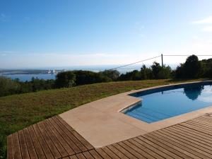 a swimming pool on a hill with a view of the water at Ha Mar ao Luar in Setúbal