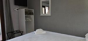 a bedroom with a white bed with a mirror at Acacia at Greenway Woods in White River
