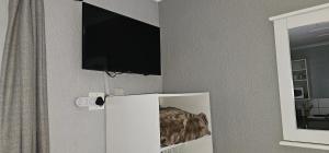 a flat screen tv on a wall above a refrigerator at Acacia at Greenway Woods in White River