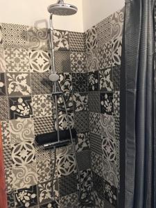 a shower with a black and white patterned wall at Émeraude baie Mont Saint Michel in Marcey-les-Grèves +19 photos