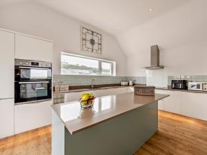 une cuisine avec des armoires blanches et un bol de fruits sur un comptoir dans l'établissement 4 Bed in Westward Ho 94726, à Westward Ho