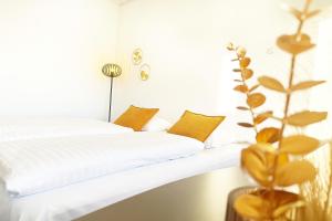 科瑟Hotel Svanegården的一间卧室配有带白色床单和黄色枕头的床。
