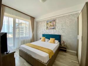 a bedroom with a large bed and a television at Maria Summer Apartaments in Mamaia