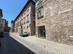 une voiture garée devant un bâtiment en pierre dans l'établissement La Casa sul Corso, à Ascoli Piceno