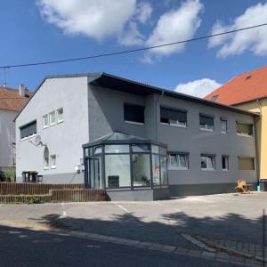 a building with a dog sitting in front of it at Monteurzimmer Saarland in Merchweiler