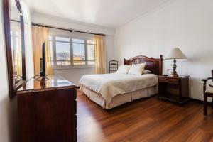 a bedroom with a bed and a dresser and a television at El Rey Palace Hotel in La Paz