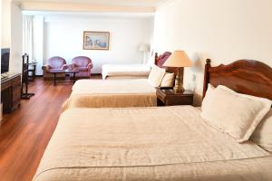 a hotel room with two beds and a television at El Rey Palace Hotel in La Paz