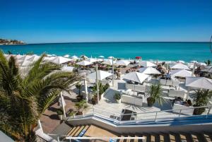 a view of a beach with white umbrellas and the ocean at Centre - Climatisation - Calme - Cuisine - Wifi - Tramway in Nice