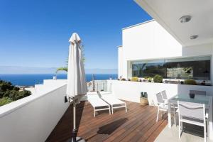 a balcony with an umbrella and a table and chairs at Amazing, Sea Views & Terrace in Santa Úrsula