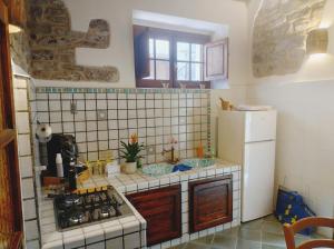 a small kitchen with a stove and a refrigerator at Casa vacanze il ciclope in Erice