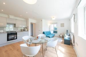 une cuisine et un salon avec une table et des chaises dans l'établissement Kingston Centre Location 2 Bed Apartment, à Kingston upon Thames