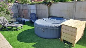 a backyard with a large tub and a table and a bench at studio indépendant proche de la mer LE Bon Secours in Dieppe +6 photos