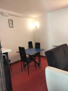 a room with a table and chairs and a couch at Appartement Cosy à Nemours Hameau Chaintreauville in Saint-Pierre-lès-Nemours