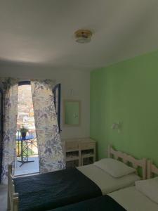 a bedroom with two beds and a window at Panorama Hotel in Kalymnos