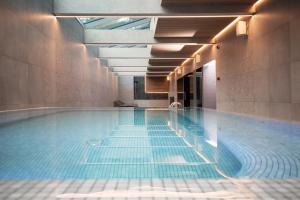 a swimming pool with blue water in a building at SPA Nida in Nida