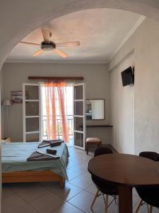 a bedroom with a bed and a table and a ceiling fan at Christina Sea View in Ágios Konstantínos