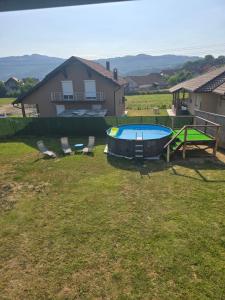 Un patio trasero con piscina, mesa y sillas. en Apartmani Dimitrijevic, en Bajina Bašta
