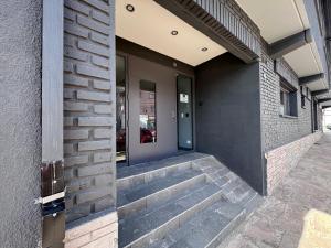 a building with stairs leading to a door at Rolando Beds in San Carlos de Bariloche