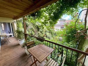 a wooden porch with a wooden bench on a balcony at Autour d'une Toile in Rouvenac