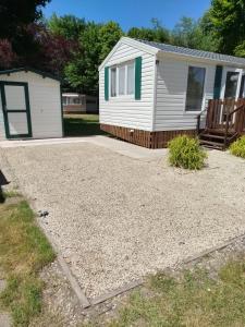a gravel driveway in front of a house at Mobil home Le Duo Tranquille in Souvigné