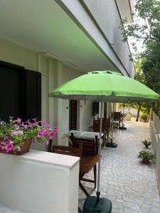 a green umbrella on a patio with tables and chairs at I Tramonti del Salento in Gallipoli