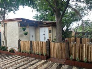 a small house behind a fence with a tree at Estudio San Felipe in Oaxaca City +3 photos