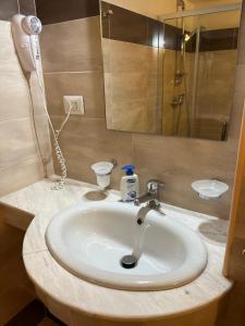 a bathroom with a sink and a shower and a mirror at I Tramonti del Salento in Gallipoli