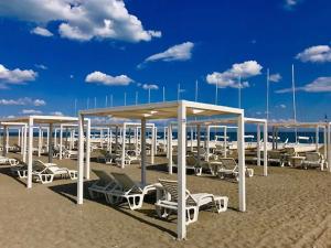 a group of chairs and umbrellas on a beach at Aquarius Policoro in Policoro