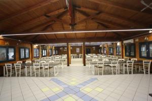 a dining hall with tables and white chairs at Aquarius Policoro in Policoro