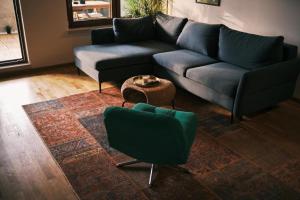 a living room with a blue couch and a table at Ikigai Penthouse Apartment in Banja Luka