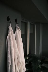 two white towels hanging on a wall next to a window at Ikigai Penthouse Apartment in Banja Luka +27 photos