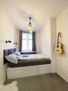 a bedroom with a bed with a guitar on the wall at 67-Ratusz - DeerRest Apart in Jelenia Góra