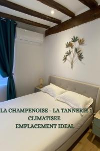 a bedroom with a bed with a sign on the wall at La Champenoise La Tannerie in Troyes
