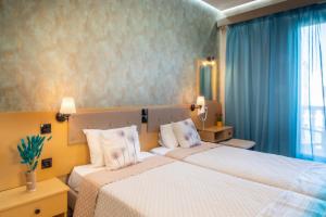 a hotel room with two beds and a window at Dionysos Studios in Laganas