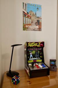 a video game machine sitting on top of a wooden floor at Le Charme des Remparts Boulonnais in Boulogne-sur-Mer