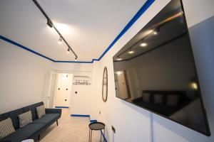 a living room with a black couch and a flat screen tv at Syntagma Center Suite by Zeus Suites in Athens
