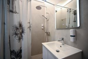 a bathroom with a sink and a shower with a mirror at Syntagma Center Suite by Zeus Suites in Athens +17 photos