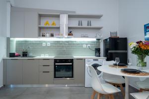 a kitchen with white appliances and a table with chairs at Jardin maison in Itea