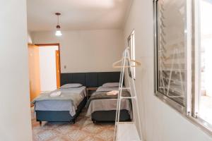 two beds in a room with a ladder at Hotel Pousada Villa Itália - Cabreúva in Cabreúva