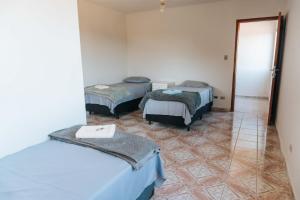 カブレウーヴァにあるHotel Pousada Villa Itália - Cabreúvaのベッド3台と鏡付きの部屋