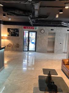 - un hall avec un canapé et une horloge murale dans l'établissement NBG Apartments, à Batoumi 11 autres photos
